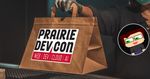 A woman holding a brown paper bag with the Prairie Dev Con logo on it , seemingly handing it to someone on the other side who is not visible in the photo.